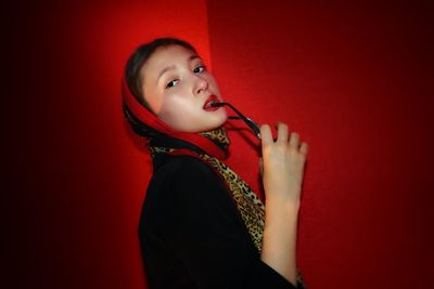 Portrait of a woman against red background