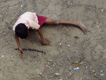 High angle view of man lying on sand