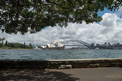 Bridge over river against cloudy sky