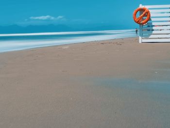 Lifeguard hut on beach against blue sky