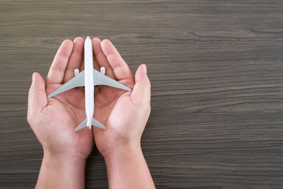 Directly above shot of hand holding paper on table
