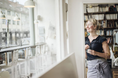 Smiling woman in a cafe looking out of window