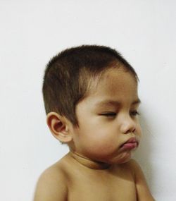 Close-up portrait of cute boy against white background