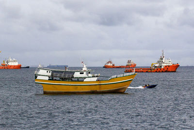 Boats sailing in sea against sky