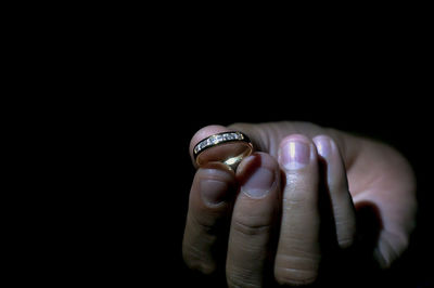 Close-up of human hand against black background