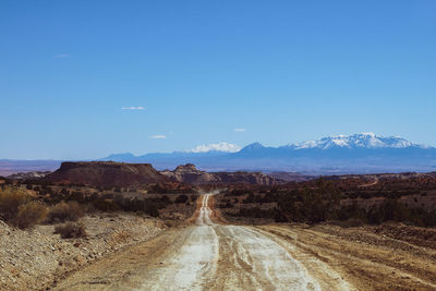 Empty back dirt roads in utah with mountains in distance