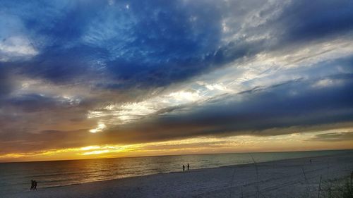 Scenic view of sea against dramatic sky during sunset