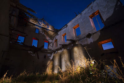 Low angle view of abandoned building against sky at night