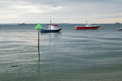 Boat moored in sea against sky