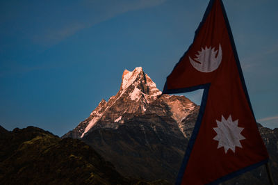 Low angle view of flag against mountains