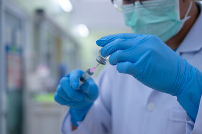 Close-up of hand holding blue umbrella