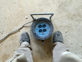 Low section of man standing on metal