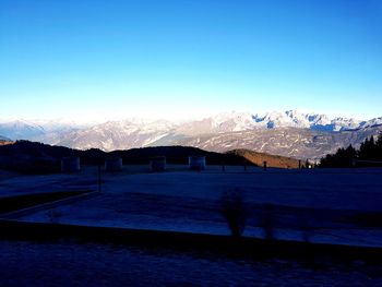 Scenic view of snowcapped mountains against clear blue sky