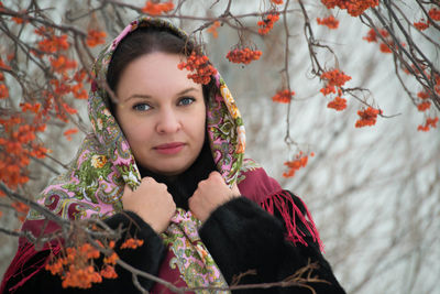 Portrait of young woman with red flowers