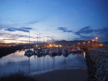 Boats moored at harbor during sunset