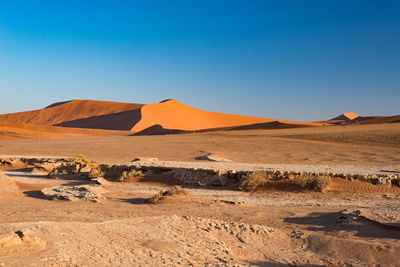 Scenic view of desert against clear blue sky