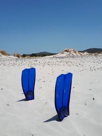 Blue umbrella on sand against the sky