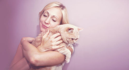 Portrait of young woman holding cat