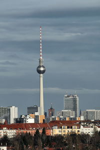 Communications tower in city against sky at night