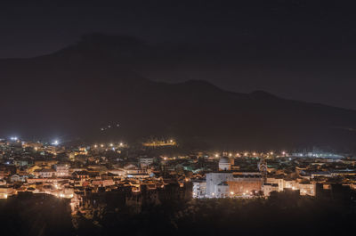 High angle view of illuminated buildings in city at night