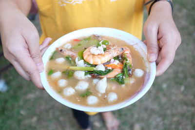 Midsection of man holding soup in bowl