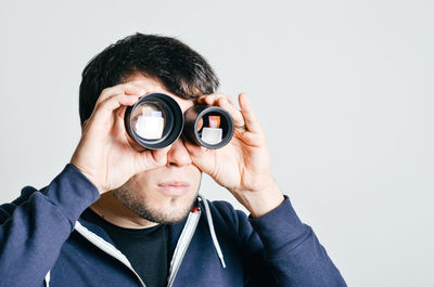 Portrait of man looking through lenses