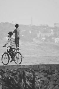 Father cycling with son on street