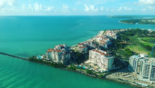 High angle view of cityscape by sea against sky