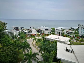 Houses by sea against sky