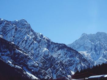 Snowcapped mountains against cloudy sky