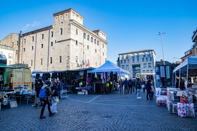 People walking on street amidst buildings in city