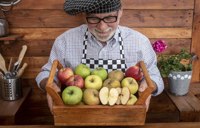 Smiling man holding fruits in kitchen