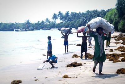 People on beach against clear sky