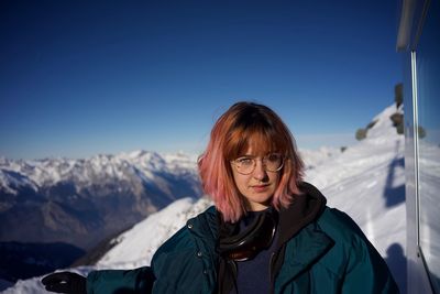 Portrait of woman on snowcapped mountains against sky