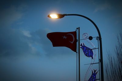 Low angle view of illuminated street light against sky