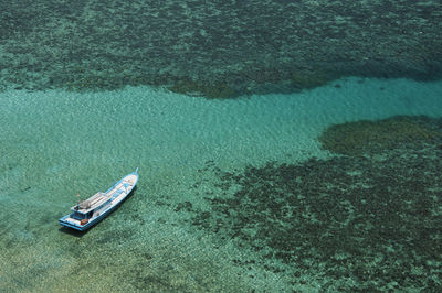 Traditional wooden boat floating on the java sea clean water isolated by coral reef