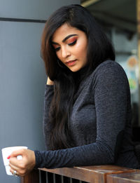 Thoughtful young woman holding coffee cup in cafe