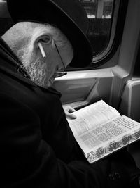 Midsection of man reading book