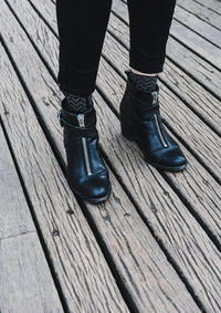 Low section of woman standing on boardwalk