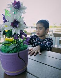 Woman looking at potted plant on table