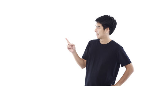Young man looking away against white background