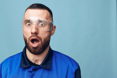 Portrait of young man against blue background