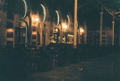 Illuminated street lights by building at night