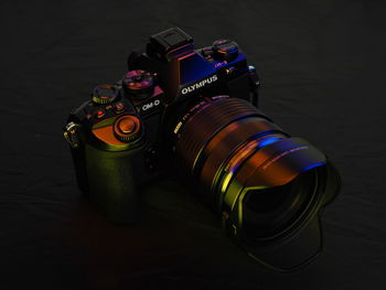 Close-up of camera on table against black background