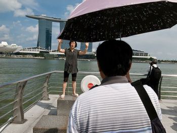 Rear view of woman sitting on pier