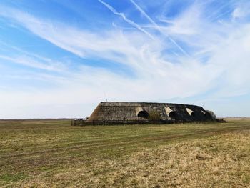 Abandoned building on field against sky