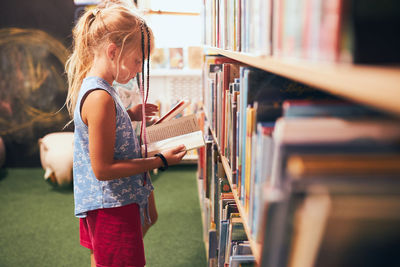 Rear view of woman standing in library