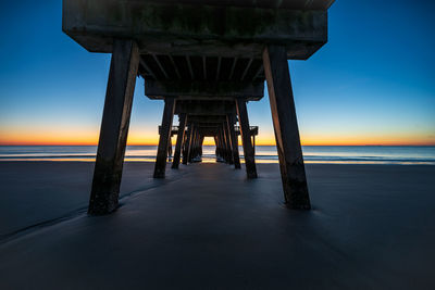 Pier on sea against sky during sunset