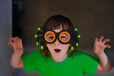 Child in carnival glasses looks at the camera and scares you. halloween preparation