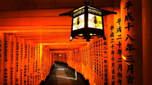 Illuminated text amidst buildings at temple during entrance of building